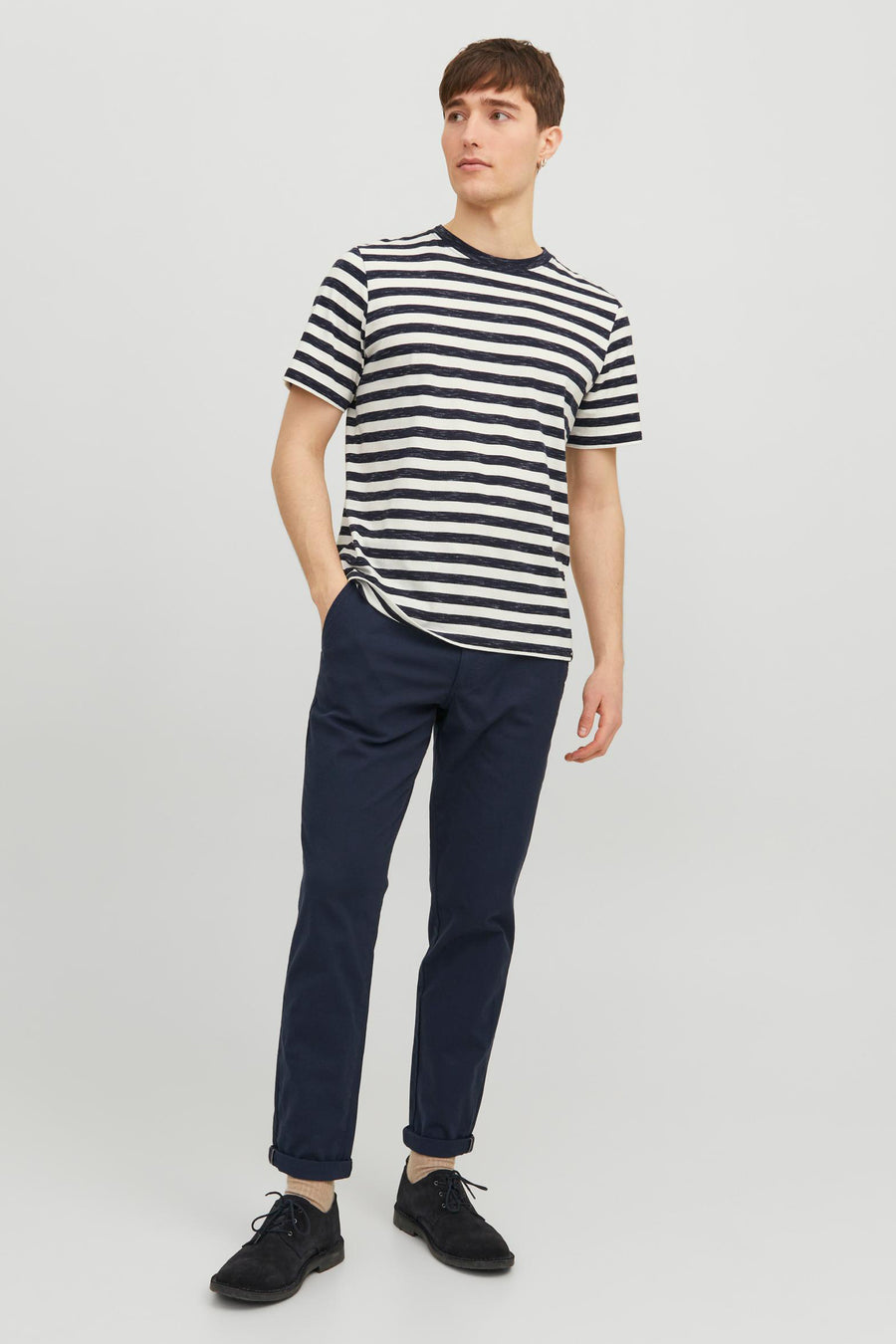 Chino bleu par JACK & JONES JEANS INTELLIGENCE, avec ourlets retroussés, porté avec un t-shirt rayé et des chaussures noires.

