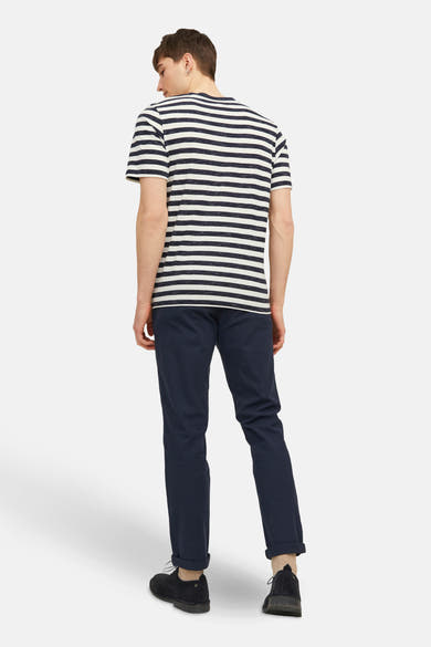Chino bleu marine de JACK & JONES JEANS INTELLIGENCE, porté avec un t-shirt rayé et des chaussures noires.