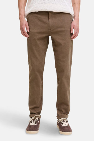 Chino beige par JACK & JONES JEANS INTELLIGENCE, porté avec un pull blanc et des baskets marron.