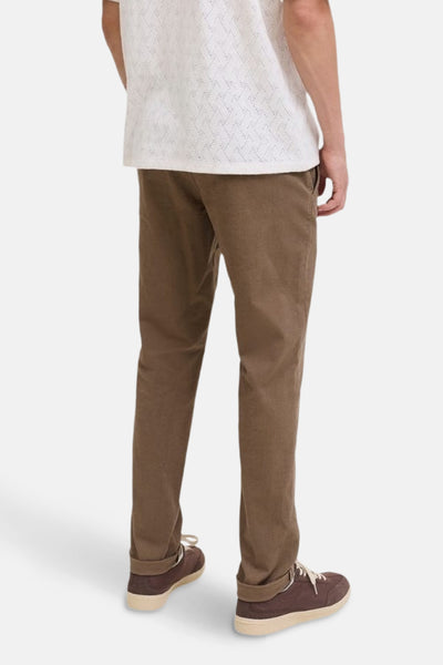 Chino beige par JACK & JONES JEANS INTELLIGENCE, porté avec un t-shirt blanc à motifs ajourés et des chaussures marron.