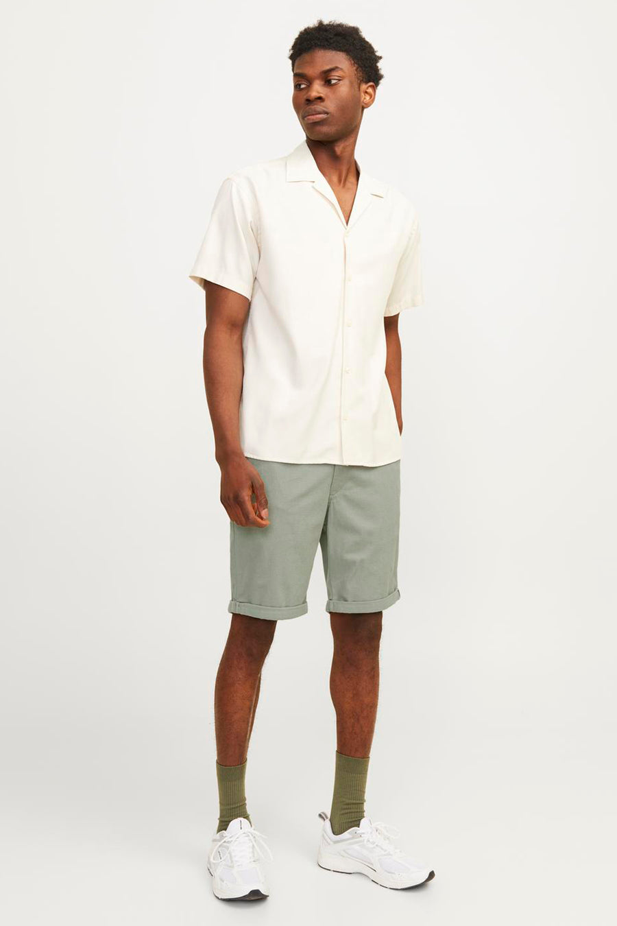 Korte groene van JACK & JONES JEANS INTELLIGENCE, gedragen met een wit overhemd en witte sneakers.