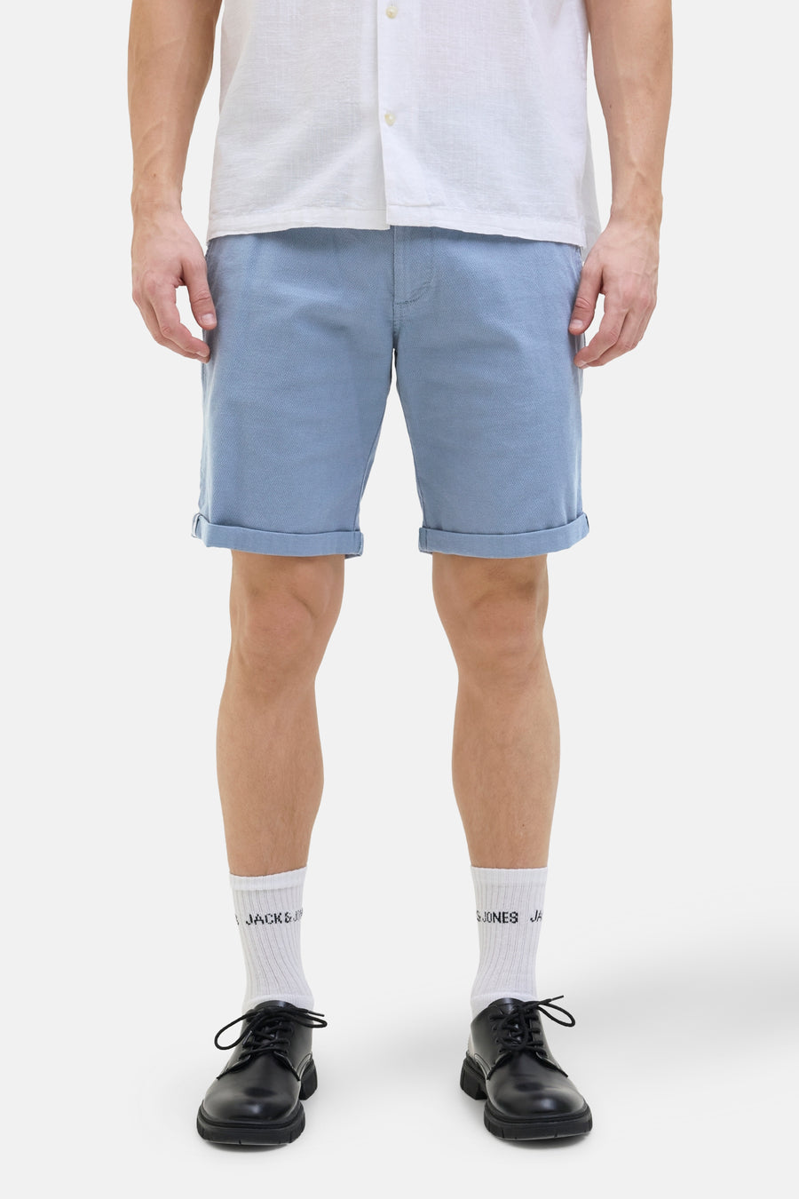 Korte blauwe van JACK & JONES JEANS INTELLIGENCE, met knie-omslagen, gedragen met wit overhemd en zwarte schoenen.