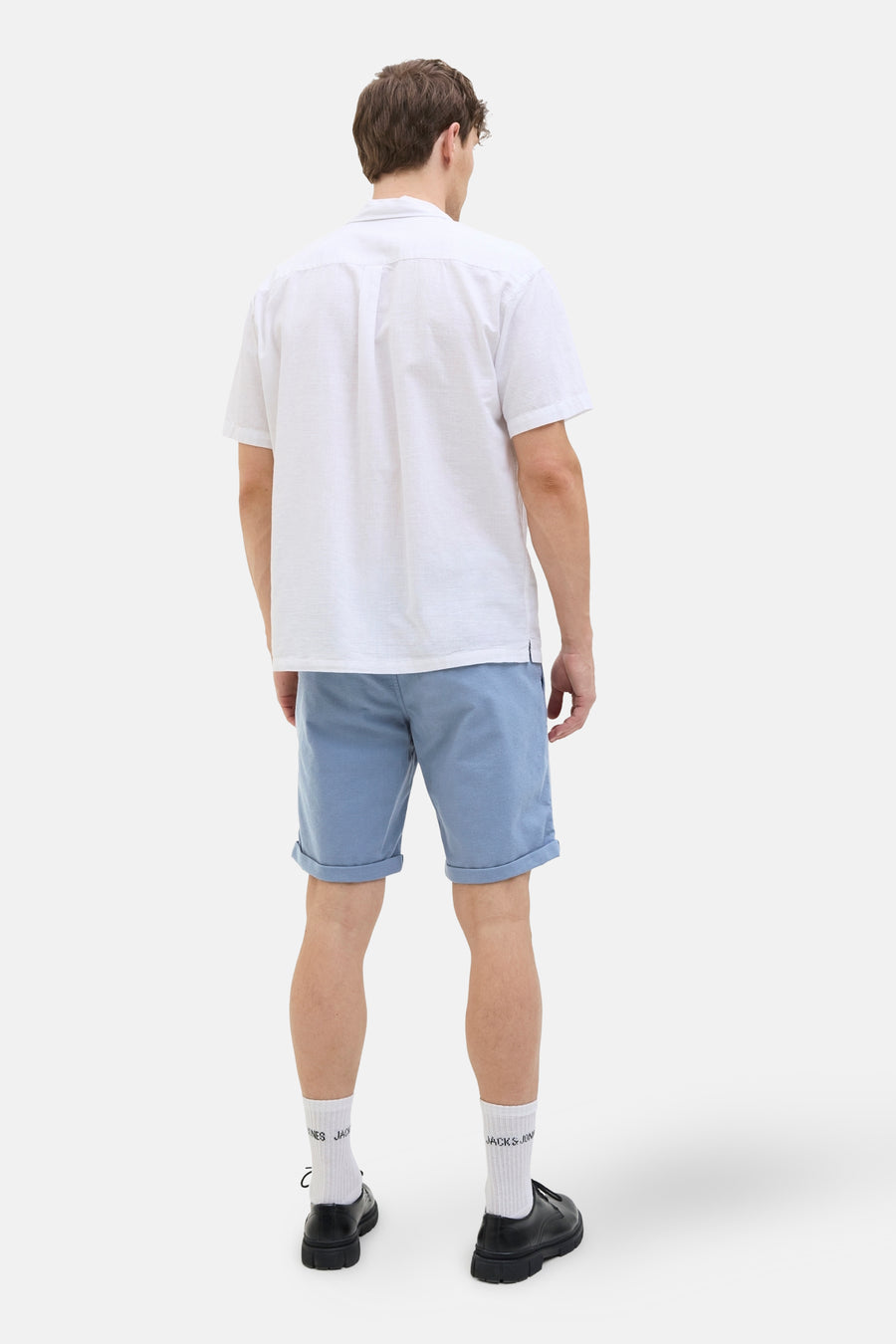 Korte blauwe van JACK & JONES JEANS INTELLIGENCE, gedragen met een effen wit poloshirt en bedrukte witte sokken.