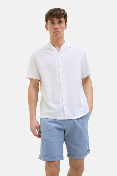 Korte blauwe van JACK & JONES JEANS INTELLIGENCE, met omgeslagen zomen, gedragen met een wit overhemd met knopen.