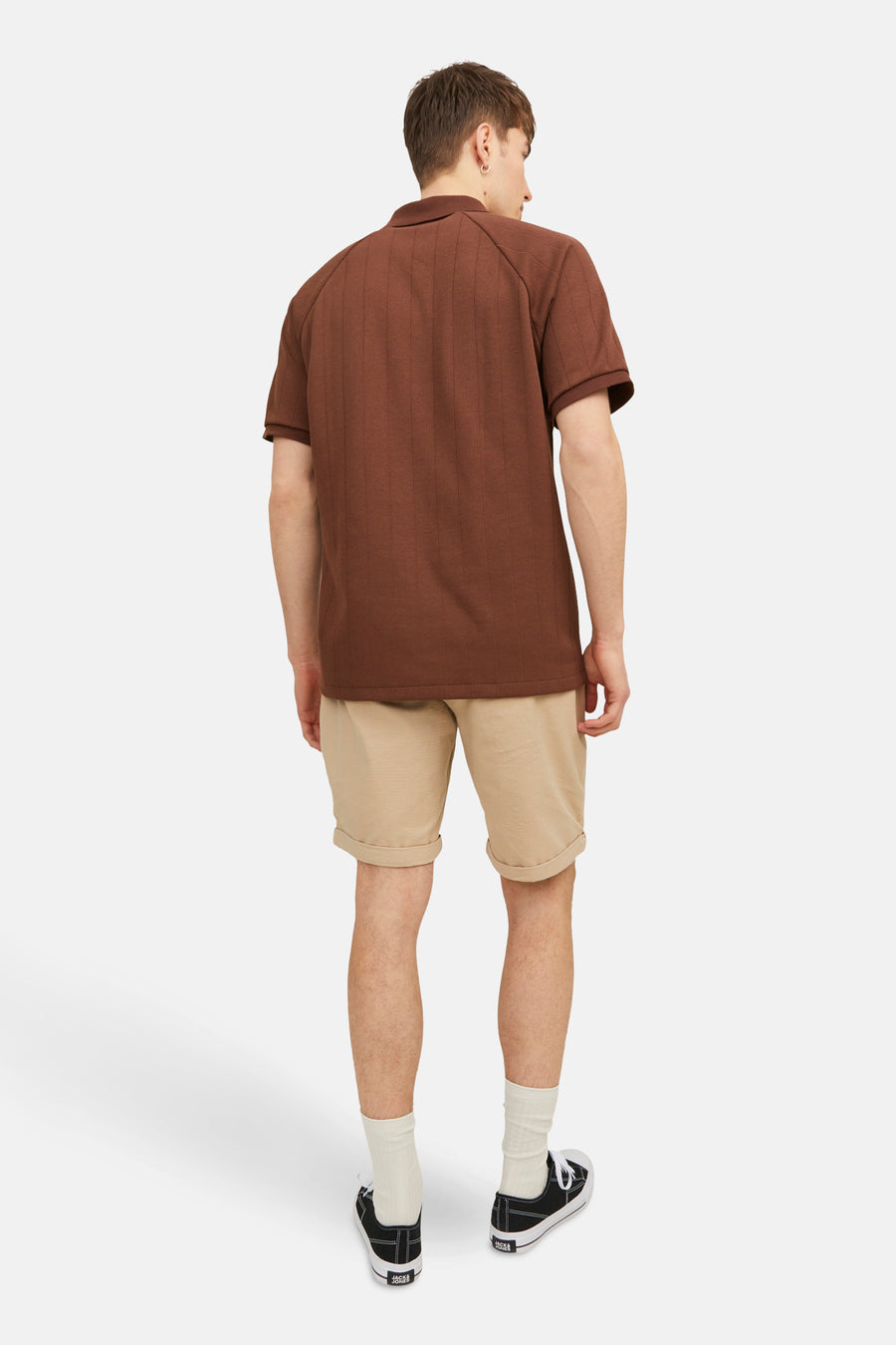 Korte beige short van JACK & JONES JEANS INTELLIGENCE met omgeslagen zomen, gedragen met een bruin poloshirt.