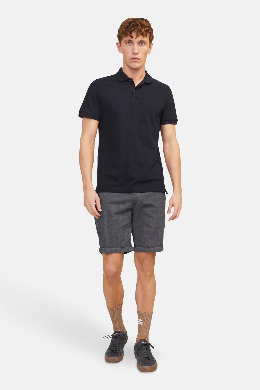 Short bleu de JACK & JONES JEANS INTELLIGENCE, porté avec un polo noir, des chaussettes marron et des baskets.