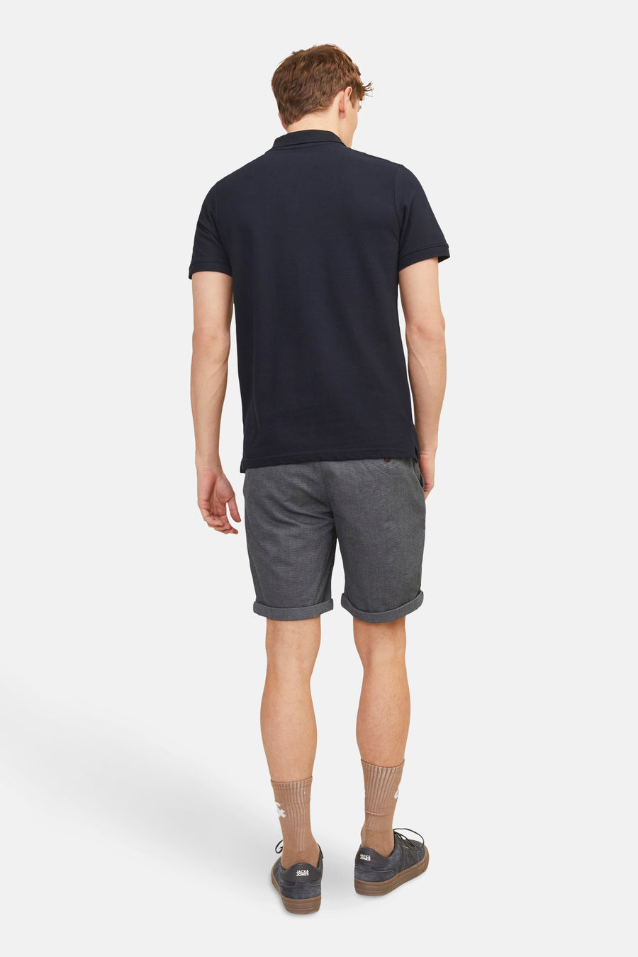Short bleu de JACK & JONES JEANS INTELLIGENCE, porté avec un polo bleu marine, des chaussettes marron clair et des chaussures noires.