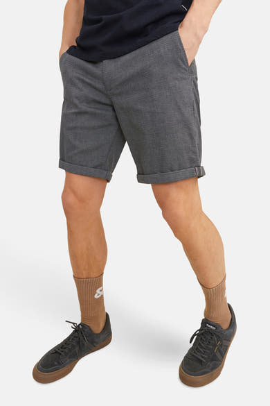 Short bleu chiné de JACK & JONES JEANS INTELLIGENCE, porté avec des chaussettes marron clair et des baskets noires.