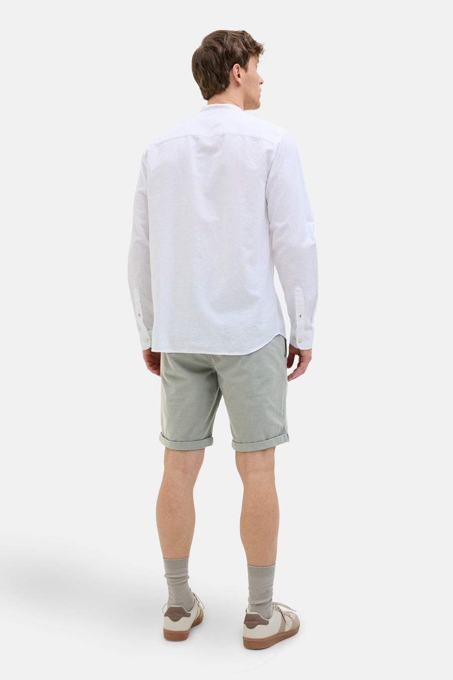 Korte groene broek van JACK & JONES JEANS INTELLIGENCE, met omgeslagen zoom, gedragen met een wit overhemd en sneakers.