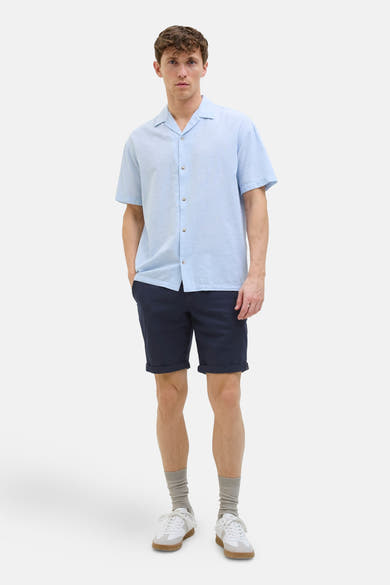 Short bleu de JACK & JONES JEANS INTELLIGENCE, porté avec une chemise bleue et des baskets blanches.
