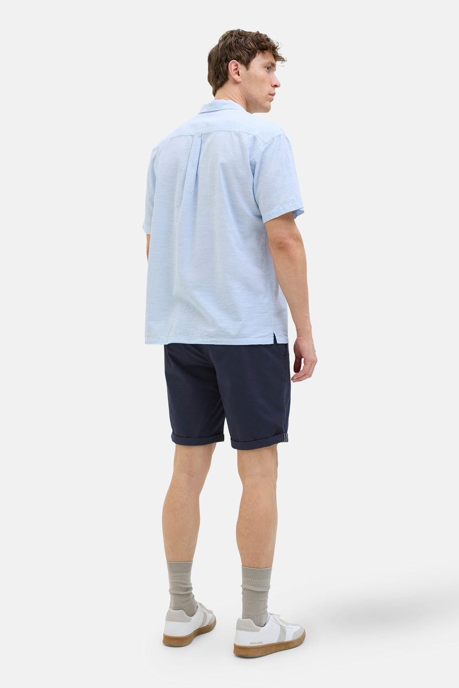 Short bleu de JACK & JONES JEANS INTELLIGENCE, porté avec une chemise bleu clair, des chaussettes grises et des baskets blanches.