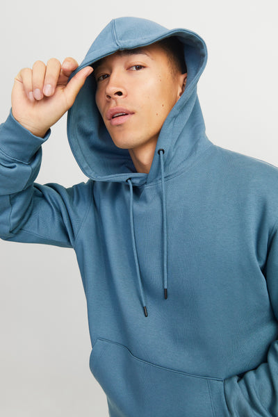 Sweat à capuche bleu par ORIGINALS BY JACK & JONES, avec cordon de serrage, porté par un homme.