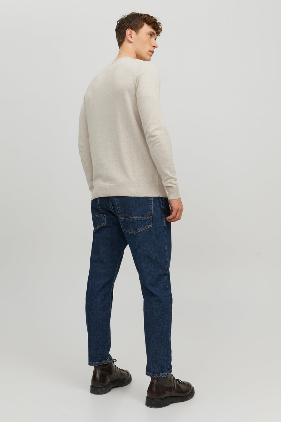 Pull beige de PREMIUM BLUE by JACK & JONES, porté avec un jean bleu foncé et des bottines en cuir marron.