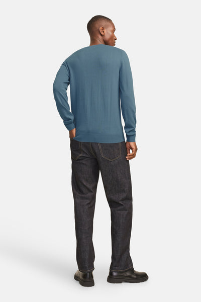 Pull à col rond bleu par PREMIUM BLUE by JACK & JONES, porté avec un jean foncé et des chaussures noires, vue de dos.
