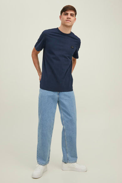T-shirt bleu à manches courtes de JACK & JONES, porté avec un jean et des baskets blanches.