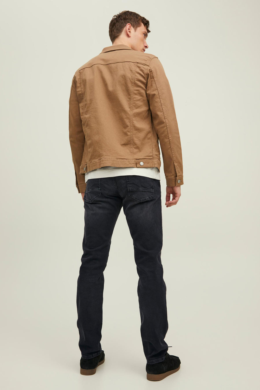 Grijze slim fit jeans van JACK & JONES JEANS INTELLIGENCE, gedragen met een bruin jasje en zwarte casual schoenen, van achteren gezien.
