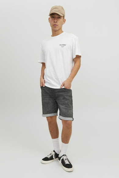 Short en denim noir de JACK & JONES JEANS INTELLIGENCE, avec ourlets roulés et porté avec un t-shirt blanc.
