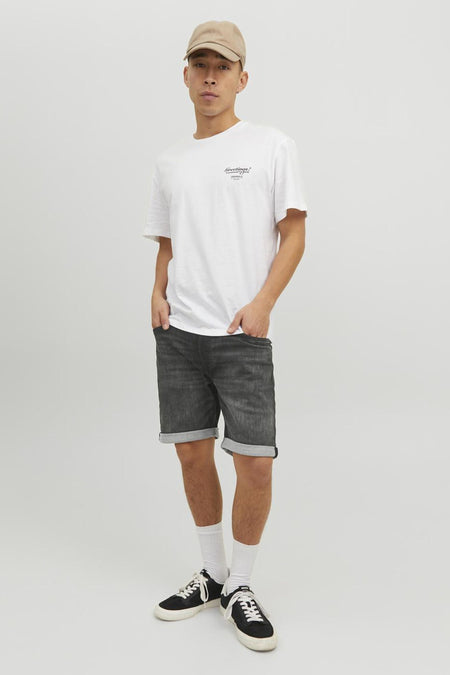 Short en denim noir de JACK & JONES JEANS INTELLIGENCE, avec ourlets roulés et porté avec un t-shirt blanc.
