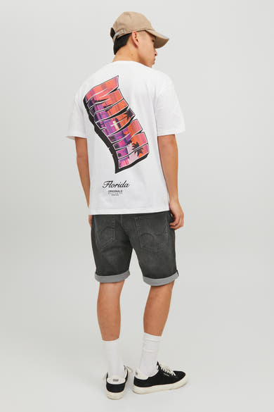 Short en denim noir par JACK & JONES JEANS INTELLIGENCE, avec ourlet retroussé, porté avec un t-shirt blanc et une casquette beige.