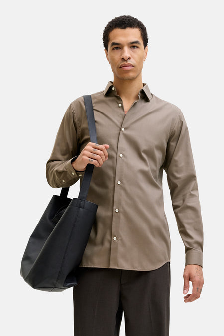 Chemise à manches longues marron de PREMIUM by JACK & JONES, portée avec un pantalon foncé et un sac noir.
