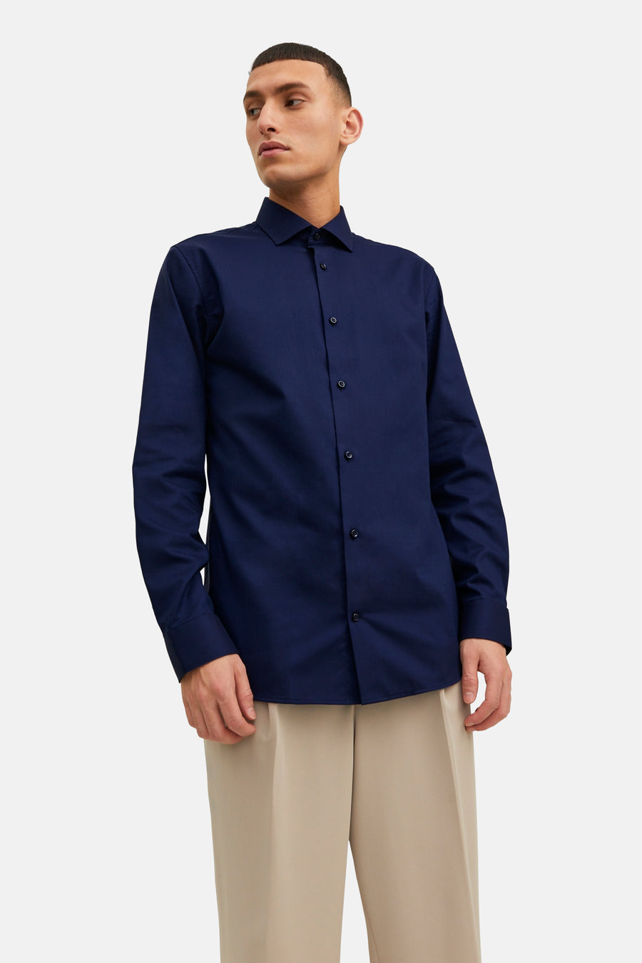 Chemise bleu marine à manches longues de PREMIUM by JACK & JONES, portée avec un pantalon beige ample.