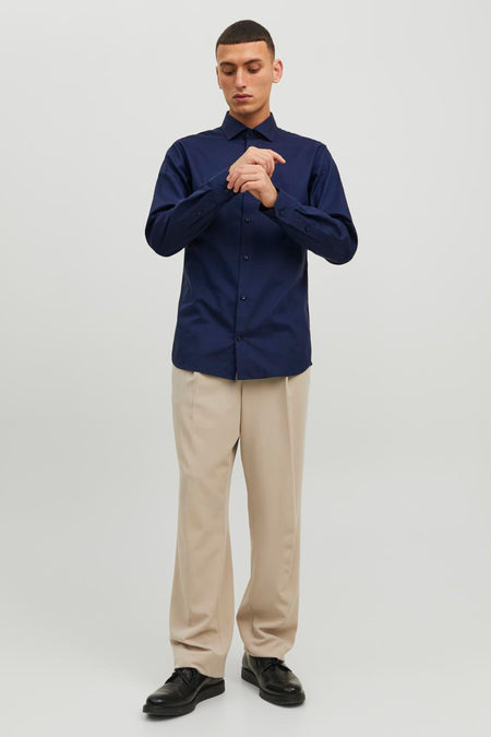 Blauw overhemd met lange mouwen van PREMIUM by JACK & JONES, gedragen met een beige broek en zwarte schoenen.