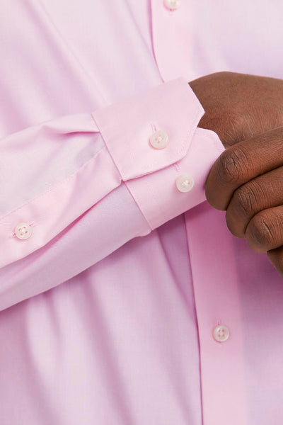 Roze lange mouw chemise van PREMIUM by JACK & JONES, zichtbare knoopmatel en donkere hand.