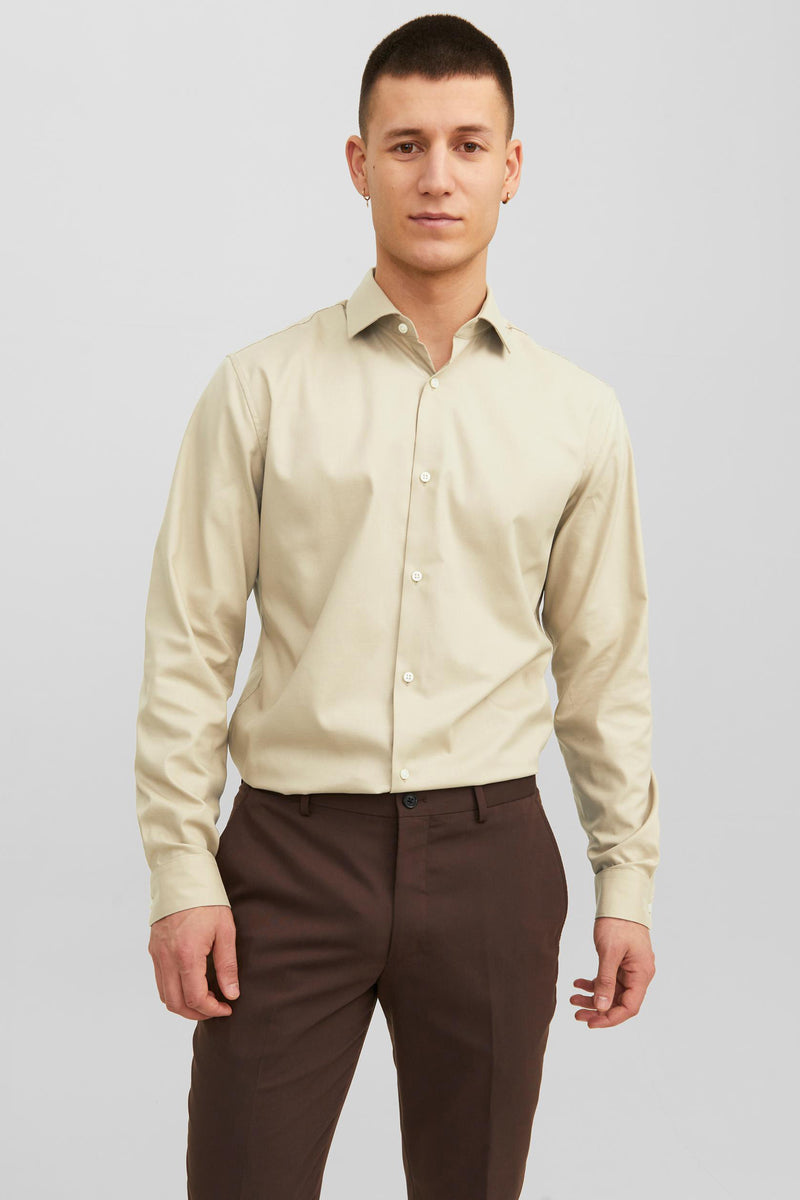 Beige overhemd met lange mouwen van PREMIUM BY JACK & JONES, gedragen met een bruine broek en zwarte schoenen.