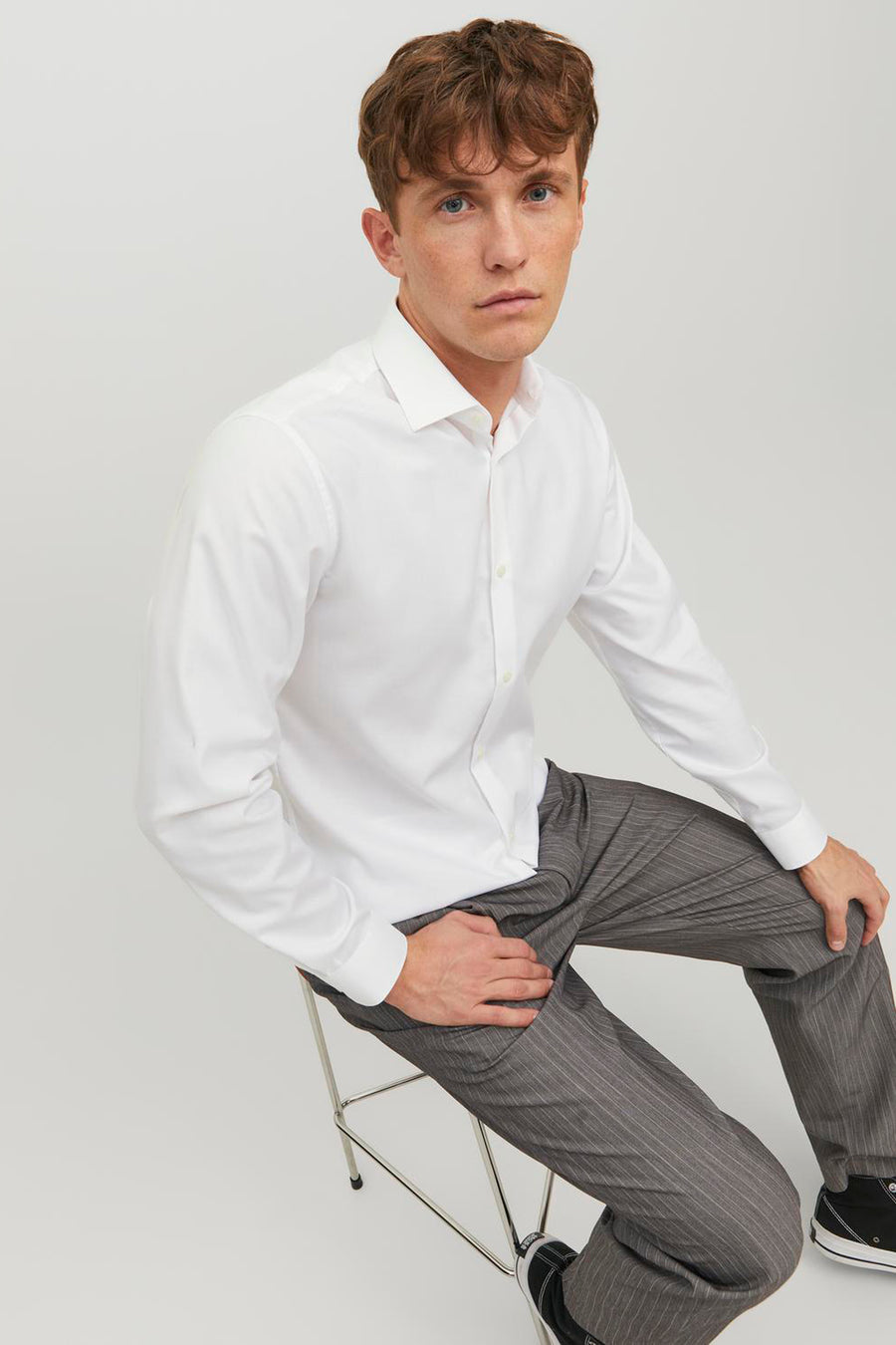 Wit overhemd met lange mouwen van PREMIUM by JACK & JONES, gedragen met een grijze gestreepte broek.