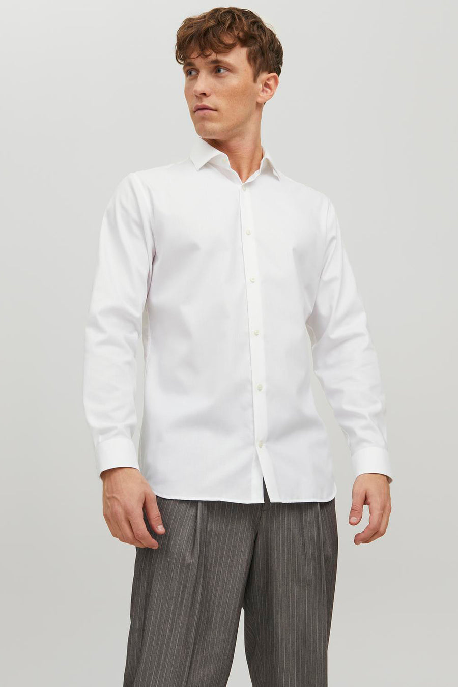 Wit overhemd met lange mouwen van PREMIUM by JACK & JONES, gedragen met een grijze gestreepte broek.