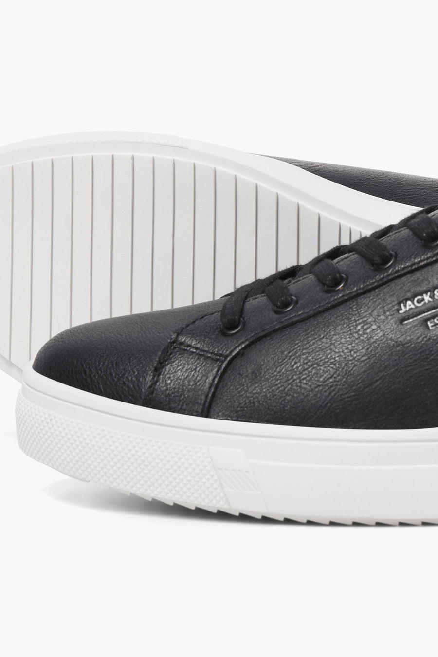 Baskets noires en cuir synthétique par ACCESSORIES BY JACK & JONES avec semelle blanche texturée, vue rapprochée.