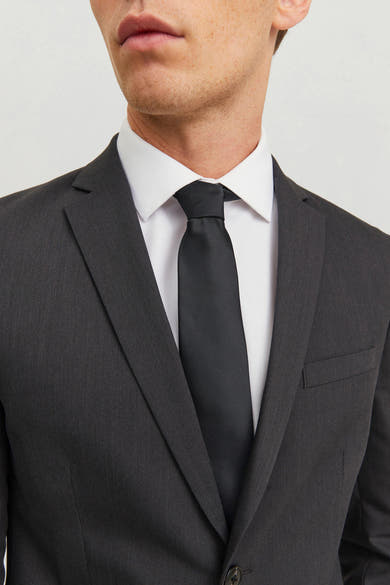 Cravate noire par ACCESSORIES BY JACK & JONES, portée avec une chemise blanche et un costume anthracite.