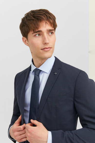 Cravate bleue de ACCESSORIES BY JACK & JONES sur une chemise bleu clair et un veston marine.