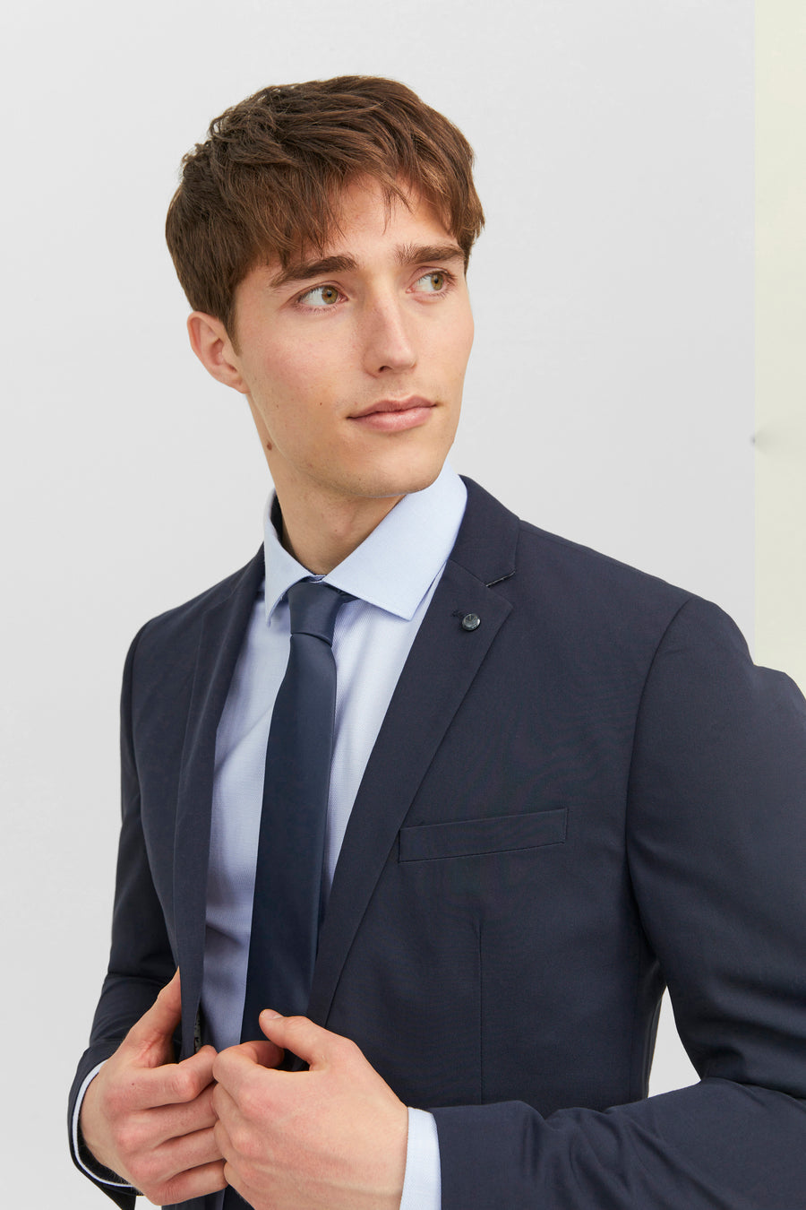 Cravate bleue de ACCESSORIES BY JACK & JONES sur une chemise bleu clair et un veston marine.