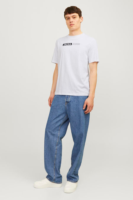 Wit T-shirt met korte mouwen van JACK & JONES, gedragen met een wijde jeans en witte sportschoenen.