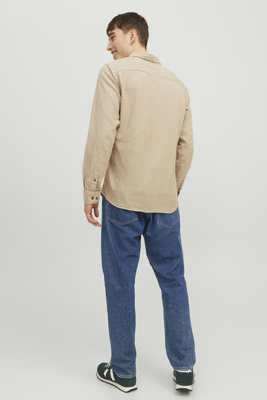 Beige overhemd met lange mouwen van ORIGINALS BY JACK & JONES, gedragen met een wijde blauwe jeans en donkere sneakers.