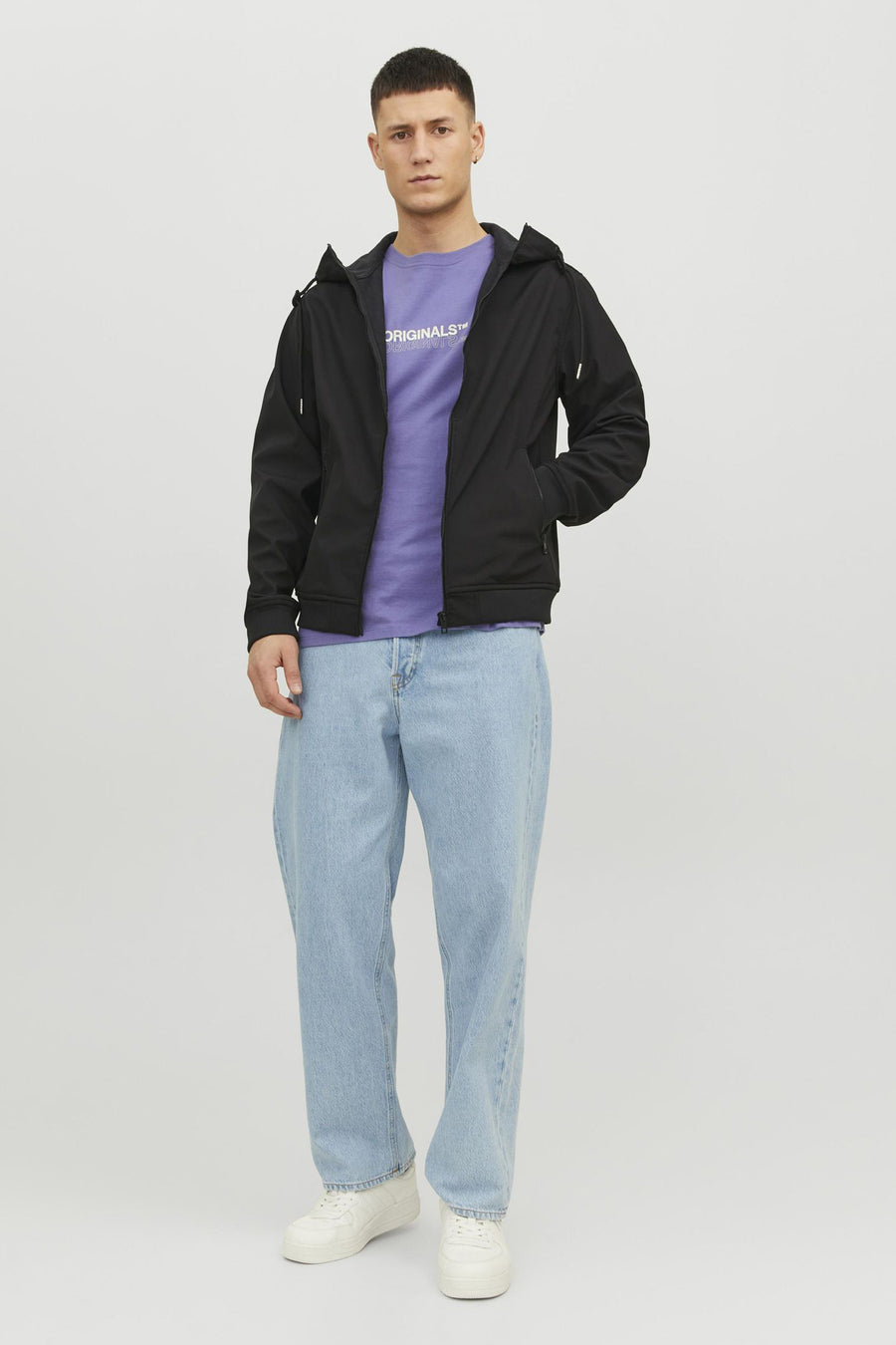 Veste courte noire JACK & JONES portée sur un t-shirt violet et un jean ample bleu clair.