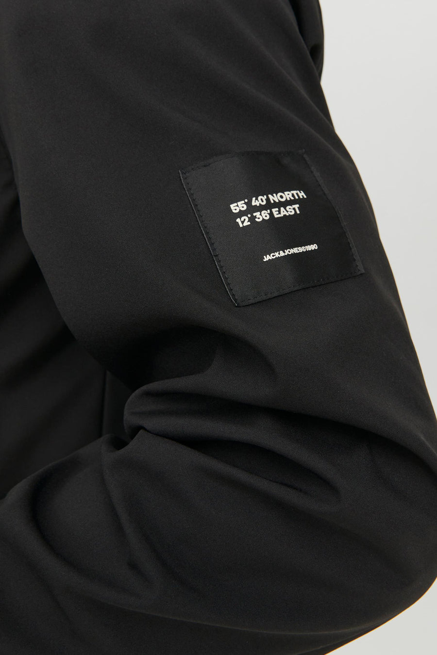 Veste courte noire de JACK & JONES, avec un patch imprimé coordonnées sur la manche.