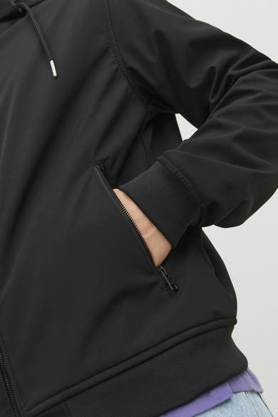 Veste courte noire de JACK & JONES avec une main dans la poche à fermeture éclair, poignet élastique.