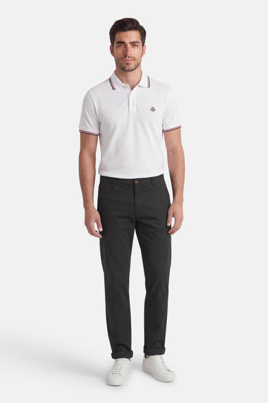 Zwarte chino JACK & JONES JEANS INTELLIGENCE, gedragen met een wit poloshirt en witte sneakers.