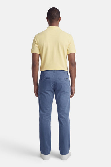 Chino bleu de JACK & JONES JEANS INTELLIGENCE, coupe droite, vu de dos, porté avec un polo jaune et des baskets blanches.