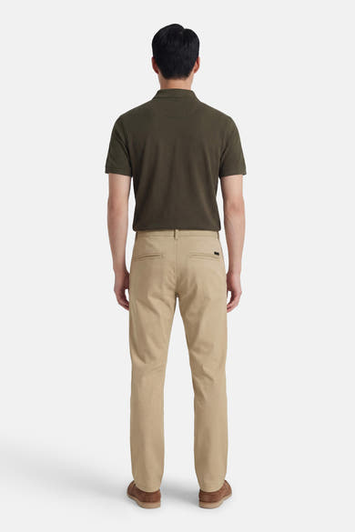 Beige chino van JACK & JONES JEANS INTELLIGENCE, achterkant, gedragen met een donkergroen poloshirt en bruine schoenen.