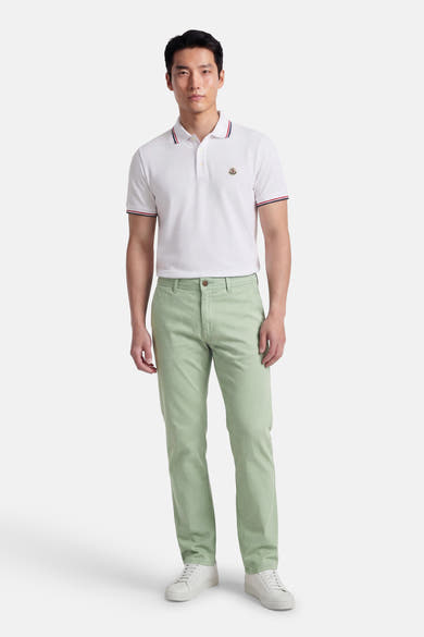 Groene chino van JACK & JONES JEANS INTELLIGENCE, gedragen met een witte polo en witte sneakers.