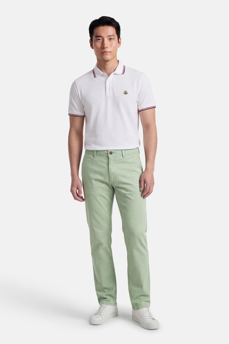 Groene chino van JACK & JONES JEANS INTELLIGENCE, gedragen met een witte polo en witte sneakers.