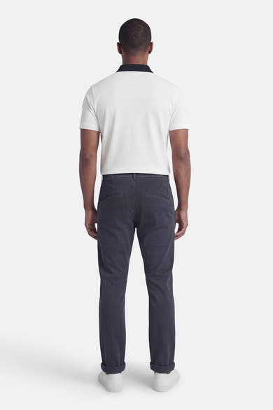 Blauwe chino van JACK & JONES JEANS INTELLIGENCE, gedragen met een witte polo en witte sneakers, achtergezicht.