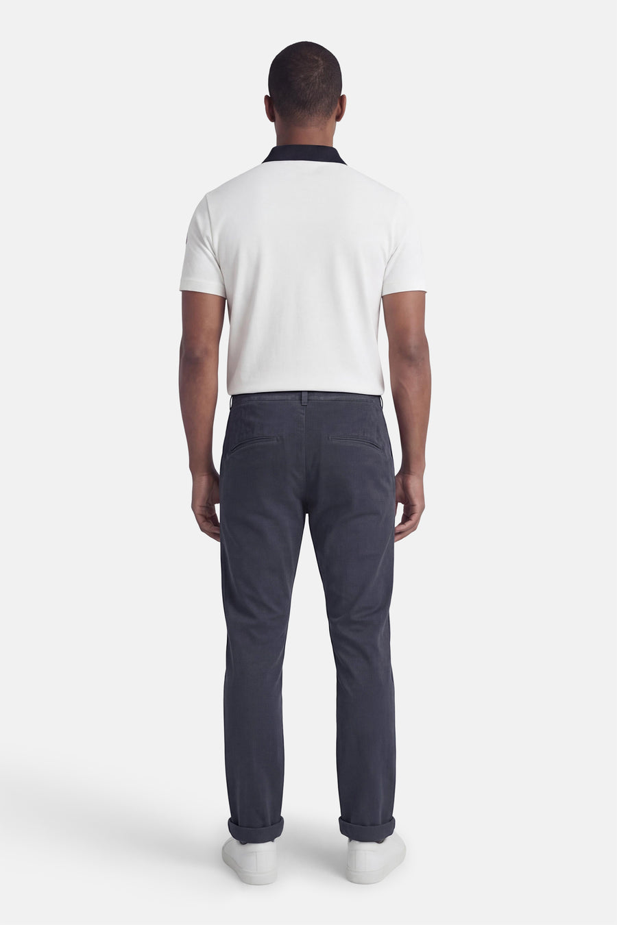 Blauwe chino van JACK & JONES JEANS INTELLIGENCE, gedragen met een witte polo en witte sneakers, achtergezicht.