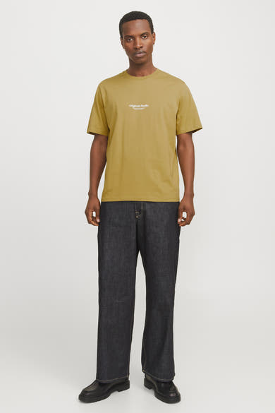 T-shirt à manches courtes vert par Originals by Jack & Jones, porté avec un jean ample et des chaussures noires.
