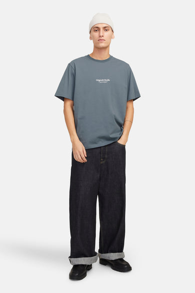 T-shirt à manches courtes bleu par ORIGINALS BY JACK & JONES porté avec un bonnet et un pantalon ample.