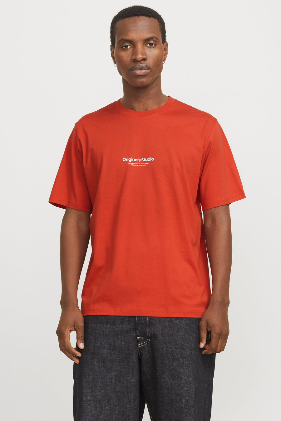 Oranje T-shirt met korte mouwen van Originals by Jack & Jones, gedragen met een spijkerbroek en zwarte schoenen.