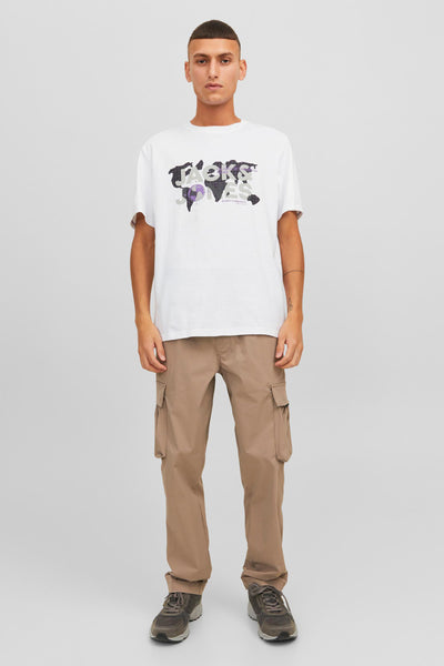 T-shirt blanc à manches courtes de JACK & JONES, avec motif imprimé, porté avec un pantalon cargo et des chaussures de sport.
